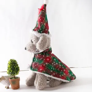 Detail view of red and green plaid Christmas pet cloak with snowflake prints and plush trim
