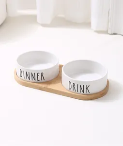 Minimalistisches Set weißer Keramik-Haustiernäpfe mit Bambustablett und Aufschrift