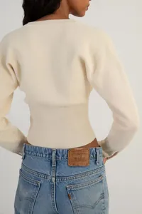 Rückansicht eines cremefarbenen kurzen Strick-Cardigans mit geripptem Saum und weichem Stoff.