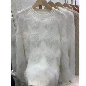 Dettaglio in primo piano del maglione bianco in finta pelliccia di visone con patchwork