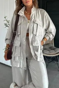 Detail view of silver metallic long-sleeved jacket featuring oversized cargo pockets