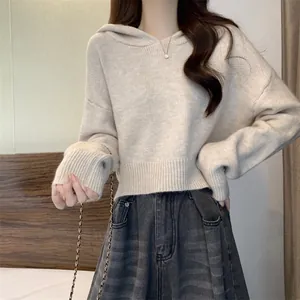 Modèle portant un pull à capuche court beige doux pour un style décontracté et confortable.