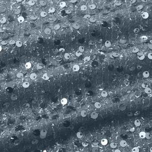 Detaillierte Makroansicht der Textur glänzender silberner Pailletten auf einem Damen-Top