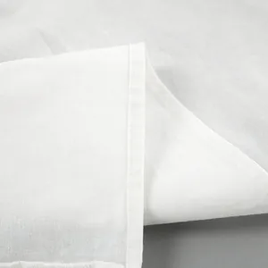 Close-up detail of white cotton linen fabric texture and stitching on summer set
