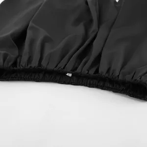 Détail en gros plan d'un haut bandeau en satin noir avec ourlet plissé et étiquette L