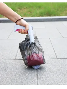 Pelle à déjection pour animaux avec sac poubelle utilisée sur sol en pierre