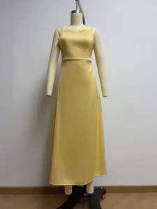 Elegant yellow satin slip maxi dress with a glossy finish on a mannequin.