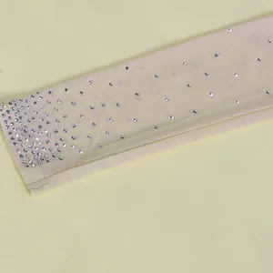 Close-up detail of sheer mesh fabric with sparkling silver rhinestone crystal accents