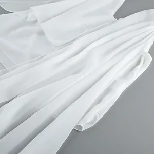 Close-up of white chiffon fabric showing elegant asymmetrical drape and sheer texture