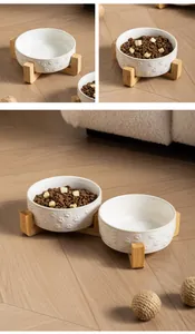 Close-up detail showing the ceramic pet bowl with paw patterns and wooden bamboo stand