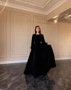 Elegant long-sleeved black maxi dress shown in a luxury classical interior setting.