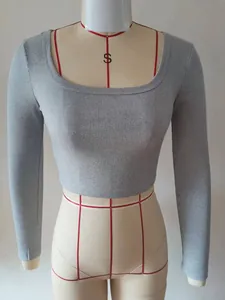 Dettaglio del tessuto a costine grigio su un crop top a maniche lunghe con scollo quadrato