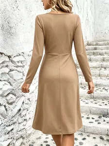 Detailed back view of a solid camel long-sleeved midi dress featuring a slim fit cut