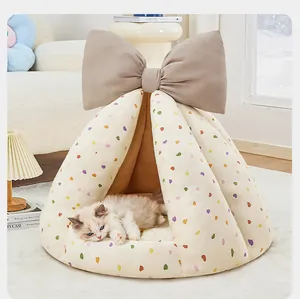 Cuccia a tenda per animali con motivi a cuore colorati e un grande fiocco