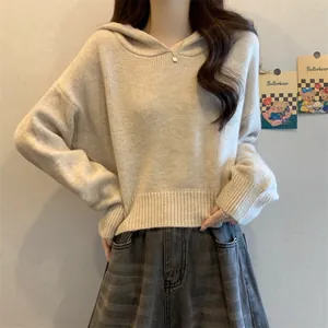 Gros plan d'un pull à capuche en maille crème pour femme avec une coupe courte et décontractée
