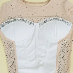 Macro detail showing sparkling rhinestones on nude mesh and white corset style bodice.