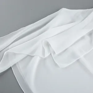 Detailed macro shot of white chiffon fabric showing elegant drape and soft texture.