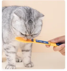 Vue détaillée d'un distributeur de friandises pour chat utilisé par un chat tigré gris.