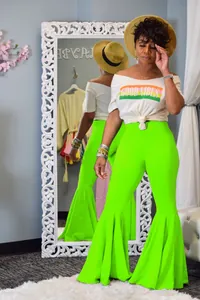 Elegantes pantalones de campana verde neón con volantes para mujer vistos en un espejo