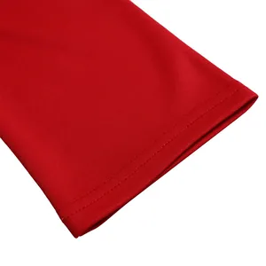 Close-up detail of the red dress sleeve showing fine double-row stitching and fabric texture