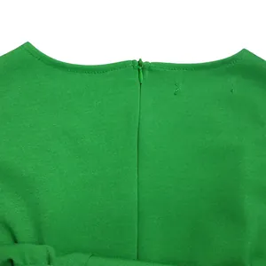 Nahaufnahme des versteckten Reißverschlusses und des grünen Stoffes des Bleistiftkleids