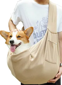 Primer plano del uso práctico de un bolso bandolera kaki para transportar perros y gatos