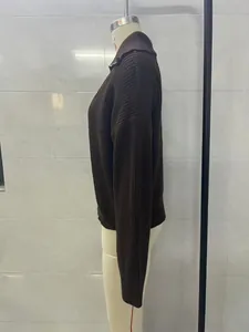 Side view of dark brown knitted sweater with ribbed texture and polo collar