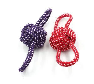 Primer plano de juguetes de nudo de cuerda de algodón tejidos a mano en violeta y rojo vivo