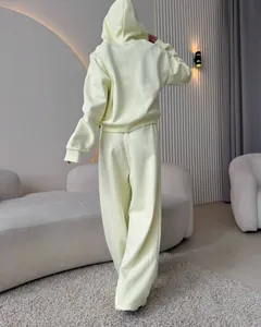 Back view of a light yellow two-piece hoodie and wide-leg pants set in a modern room