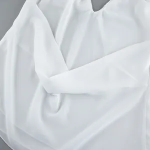 Close-up detail of the elegant white chiffon fabric texture on a French style halter top