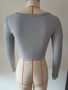 Dettaglio ravvicinato del retro di un crop top grigio a coste con maniche lunghe.