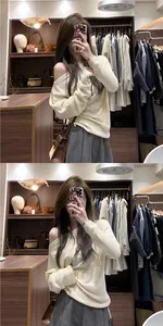 Μια λεπτομερής selfie στον καθρέφτη ενός κρεμ πλεκτού πουλόβερ με έξω τους ώμους