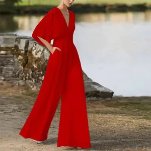 Dettaglio della tuta rossa a gamba larga con scollo a V e maniche a campana alla moda