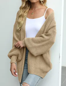Detailopname van een grofgebreid damesvest met stijlvolle lantaarnmouwen in een beige kleurvlak