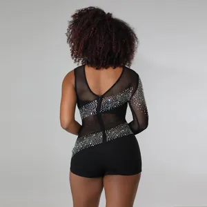 Vista posteriore di un body nero monospalla in rete con dettagli in strass luccicanti.