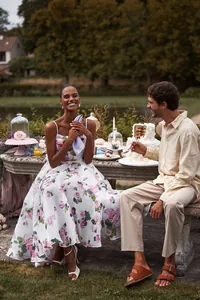 Elegant woman in floral chiffon midi evening dress during a romantic garden picnic