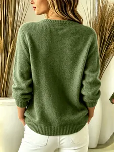 Detailed view of back of a green knit sweater with ribbed hem and cozy texture.