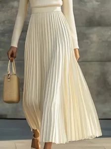 Elegante vestido largo plisado de manga larga crema para mujer en entorno chic