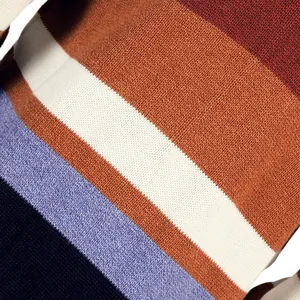 Detalle macro de la textura de punto de alta calidad de este cárdigan de rayas de colores
