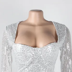 Detailed view of white sequined dress bust on mannequin, highlighting texture and fit.