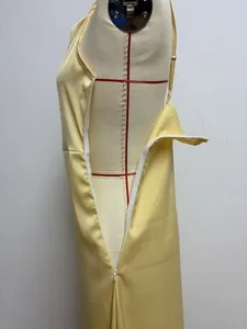 Detailed macro view of side invisible zipper on elegant yellow satin camisole evening dress