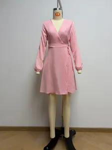 Detalle de vestido cruzado rosa de manga larga y escote en V en maniquí de exhibición