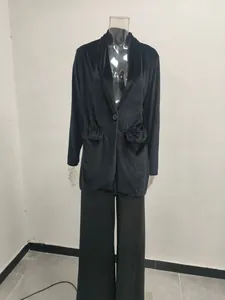 Full view of an elegant black velvet long-sleeved coat on a mannequin in a studio