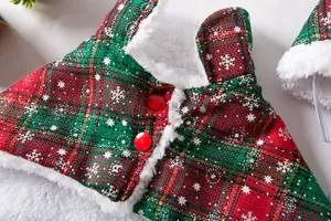 Close-up detail of festive red and green plaid pet Christmas cloak with plush trim.