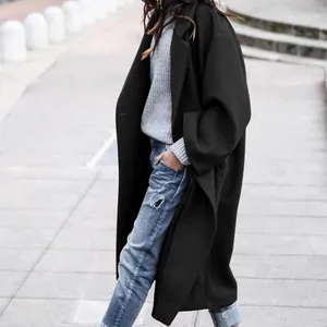 Professional model wearing a stylish long black wool coat in urban street setting