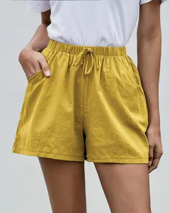 Detalle de shorts de lino amarillo corte evasé con cintura elástica y cordón ajustable.