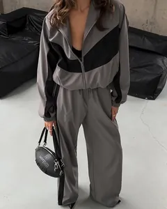 Detail of women's grey and black color block tracksuit with zip-up jacket and wide pants.