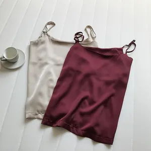 Dettaglio del tessuto di eleganti canotte in raso con spalline in due colori