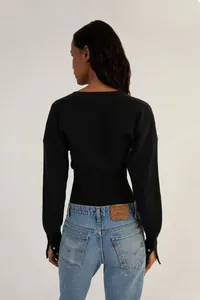 Detailansicht der Rückseite eines schwarzen, kurz geschnittenen Strickpullovers.