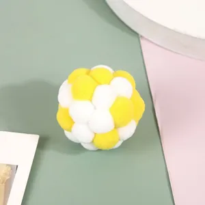 Close-up of a soft plush cat toy ball in yellow and white, perfect for pet play.